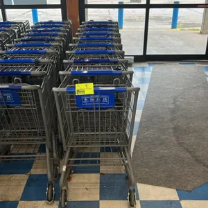 Metal wire shopping carts. Features a nesting wire basket design with a plastic child seat, blue handle sleeve, blue corner bumpers, and a lower wire 