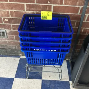 Poly shopping baskets. Features blue plastic construction, folding black handles, and 'HOMELAND' branding. Includes a wire metal storage stand.