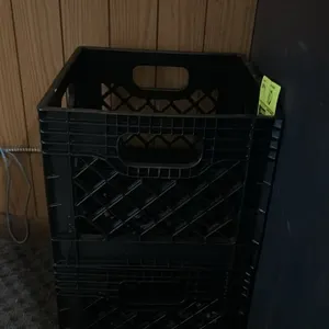 Poly milk crates. Features molded plastic construction with a grid design and integrated carry handles. Stackable.