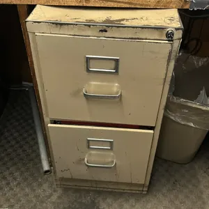Metal 2-drawer vertical filing cabinet. Features a tan painted metal construction, integrated drawer pulls, and label holders. Note: Key is not includ