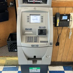 Triton ATM machine. Features a Cardtronics topper, integrated digital display, numeric keypad, card reader, and cash dispenser. Mounted on a secure ca
