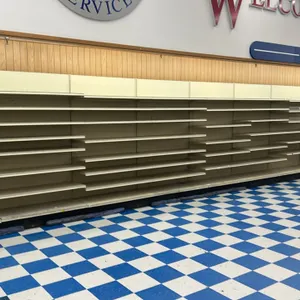 48'L of Lozier wall shelving. Features 84"H uprights with 22"D base shelves and adjustable upper metal shelves. Finished in cream-colored metal with w