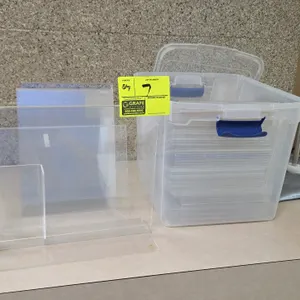 Poly signs and display accessories. Includes clear plastic sign sleeves, a lidded plastic storage tote with latches, acrylic tabletop sign holders, a 
