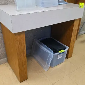 Laminate and wood stand. Features a light-colored laminate top on a sturdy wood-veneered base. Dimensions: 48" x 24" x 41". Contents not included.