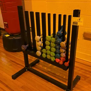 Metal weight stand with assorted weights. Includes various neoprene and vinyl-coated dumbbells from SPRI, Bollinger, and other brands. Dimensions: 34"