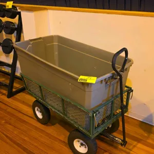 Metal 4-wheel utility wagon. Features a green steel mesh frame with fold-down sides, pneumatic tires, and a pull handle. Includes a removable grey pol
