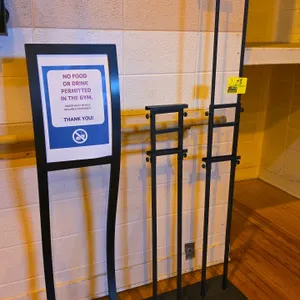 Metal sign and display stands. Includes curved-frame pedestal sign holder and adjustable telescoping graphic display stands with weighted bases. Black