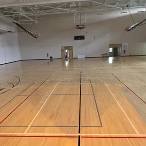 Gymnasium wood floor. Features tongue-and-groove hardwood strip construction with painted game lines and court markings. Note: Buyer is responsible fo