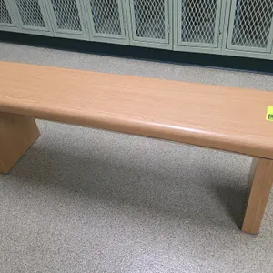 Laminate wood bench. Features a light oak wood-grain finish, rounded front edge, and solid panel legs. 48"L. Note: Small chip in the laminate on the f