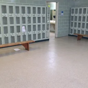Wood benches. Features solid wood construction with angled wood leg supports. Designed for locker room or gym use. Dimensions: 96"L. Lockers in backgr