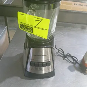 Hamilton Beach countertop blender. Features a 5-cup glass jar with graduated markings, a lid with a flip-top pour spout, and a black base with stainle