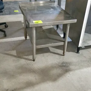 Stainless steel work table. Features a stainless steel undershelf and a rear backsplash. Dimensions: 24" x 30" x 35". Mounted on tubular legs with adj