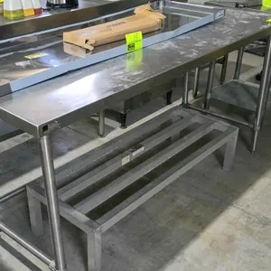 Stainless steel prep table. Features a flat work surface and an open base with H-frame cross bracing for stability. Mounted on tubular legs with adjus