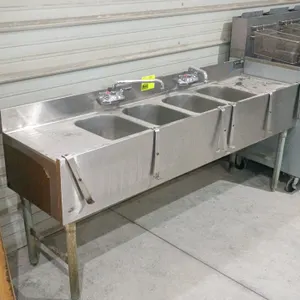 Eagle 4-compartment stainless steel underbar bar sink. Features left and right drainboards, two splash-mounted swing faucets, and front speed rail mou