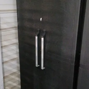 Poly 2-door storage cabinet. Features black plastic construction, two doors with vertical pull handles, and two interior shelves. Dimensions: 34"x18"x