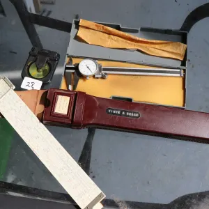 3 measuring tools including Hughes-Owens slide rule in leather case, dial calipers, and angle level 