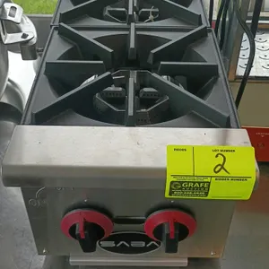 SABA gas hot plate. Features stainless steel construction, 2 burners, and cast iron grates with front manual control knobs. Dimensions: 12" x 27" x 11