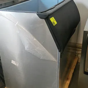 Ice-O-Matic B110PSB stainless steel ice storage bin. Features a blue polyethylene-lined interior and a top-hinged black plastic door. Protective plast