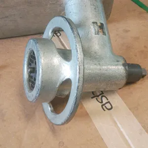 Hobart meat grinder attachment. Features cast metal grinder head, aluminum feed pan, internal feed screw, grinder plate, and threaded ring. Designed t