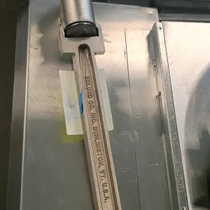 Edlund manual commercial can opener. Features a heavy-duty cast metal bar and a manual crank handle with a blue Edlund grip knob. Includes stainless s