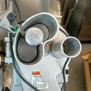 Globe GFP700 commercial food processor. Features a continuous feed design with a kidney-shaped hopper, manual pusher, and cylindrical feed tube. Power