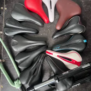 11 Mixed Bicycle Saddles and 2 Fork Assemblies, Including RockShox Tora