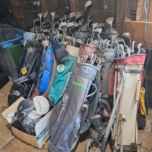 Large assortment of golf clubs with bags