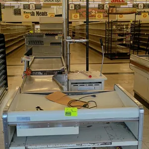 Borroughs Series 80 metal check lanes. Features integrated conveyor belts, stainless steel bagging transitions, cashier work surfaces, and lower shelv