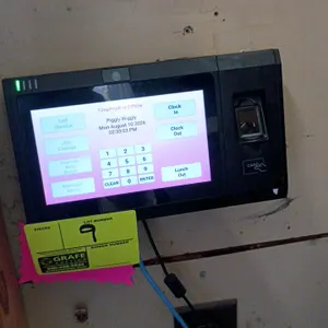 TimePro electronic biometric time clock terminal. Features a touchscreen display, integrated camera, biometric fingerprint scanner, and card reader. W