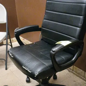 Flux office chair. Features black vinyl upholstery with ribbed back and seat design, integrated armrests, and pneumatic height adjustment. Mounted on 