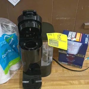 Keurig coffee maker and assorted supplies. Includes a Keurig single-serve coffee maker, a box of Maxwell House K-Cups, paper towels, disposable foam a