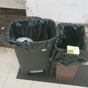 Poly trash cans. Includes one black step-on trash can with a foot pedal and one brown rectangular wastebasket.