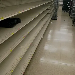 128'L of Madix gondola shelving. Features off-white finish, 72"H uprights, and 25"/25" double-sided base shelves. Pegboard backing. Contents and aisle