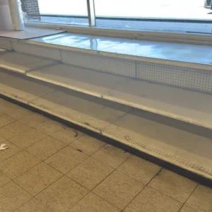 20'L of Madix store wall shelving. Features a 24"D base and 36"H uprights. Equipped with pegboard backing and adjustable metal shelves. Finished in of