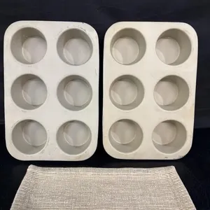 2 stoneware muffin pans with a hot pad
