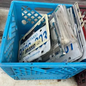 Crate of assorted license plates and covers