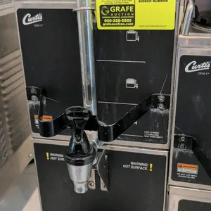 Curtis GEM-3 coffee dispenser with warming stand. Features front dispensing faucet, faucet guard, liquid level sight gauge, top carrying handles, and 