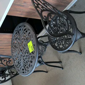 3-piece decorative metal patio bistro set. Includes 23" diameter round table with umbrella hole and (2) matching filigree scrollwork chairs. Black fin