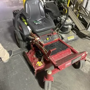 Toro Z Master zero-turn riding mower. Features a red cutting deck, black operator seat, dual steering levers, and rear drive tires. Mounted on a front