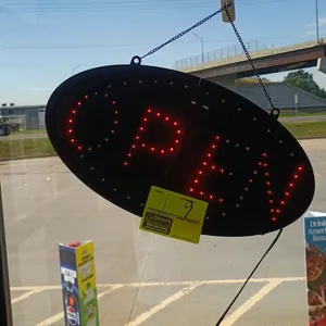 LED illuminated Open sign. Features oval black frame, red LED lettering, and hanging chain.
