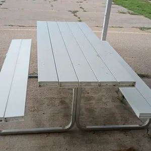 Poly picnic table. Features white poly slat tabletop and dual attached bench seats. 84"L x 62"W x 31"H. Mounted on a tubular metal frame.