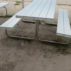 Poly picnic table. Features white poly slat tabletop with attached bench seating. 84"L x 62"W x 31"H. Mounted on a tubular metal frame.