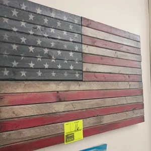 Wooden American flag wall art. Features rustic wood slat construction with a stained red, white, and blue finish with 50 stars. Dimensions: 35" x 19".