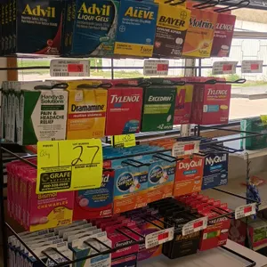 Metal countertop merchandiser display rack. Features 4 tiers of wire hanging hooks, price label channels, and top header sign. Includes displayed conv