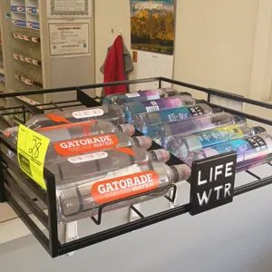 LIFE WTR countertop wire beverage display rack. Features black metal wire construction, front branding badge, and divided product lanes. Includes asso