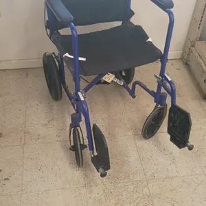 Folding transport wheelchair. Features a blue metal frame, black nylon seat and backrest, padded armrests, swing-away footrests, and rear attendant ha
