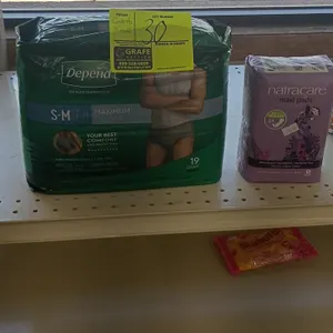 Assorted retail shelf contents. Lot includes personal care products (Depend underwear, Natracare pads), Healthy Choice canned soup, toothpicks, salad 