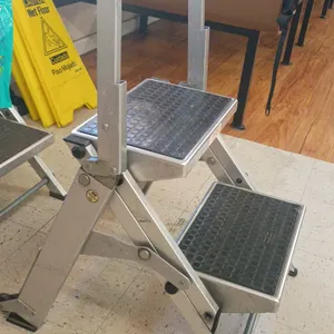 Wing 2-step folding ladder. Features an aluminum frame, integrated safety handrail, and wide slip-resistant treads.
