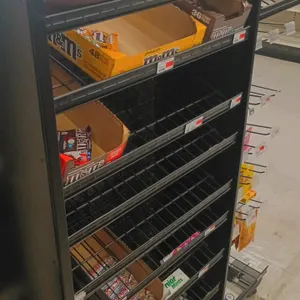 Assorted candy and retail merchandise. Includes packaged candy bars, mints, and chewing gum such as M&M's, Kit Kat, Skittles, Mentos, Trident, Orbit, 