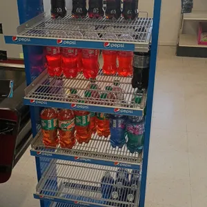 Pepsi 5-tier wire beverage display rack. Features blue metal frame, wire display shelves with label channel strips, and Pepsi branded header sign. Inc